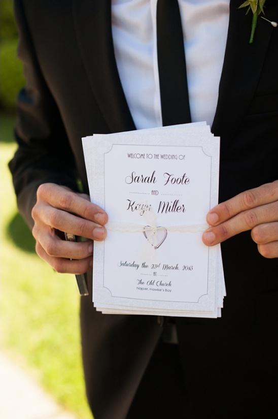 Groomsman holds Sarah & Kevin's wedding program