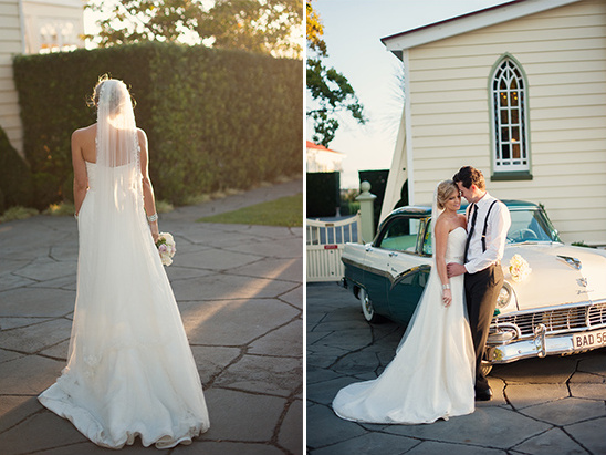 Bride and groom pose by vintage car, wedding day