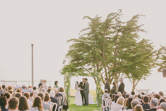 Outdoor wedding ceremony under a floral arch tree