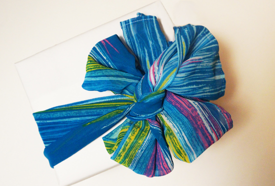 Colorful blue gift bow tied on white box