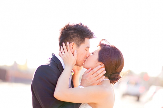 Newlywed Asian couple shares a kiss on their wedding day