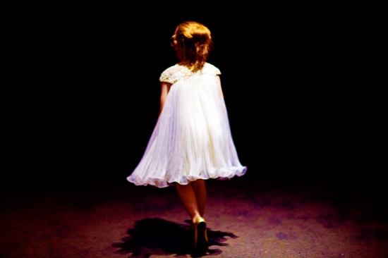 Girl in white dress walking away in the dark