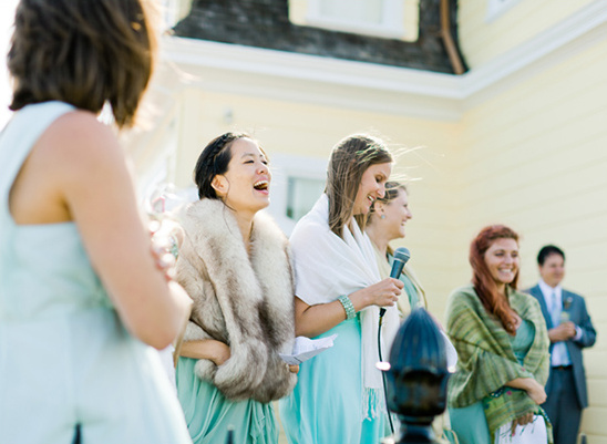 Bridesmaids giving speeches at a sunny outdoor wedding