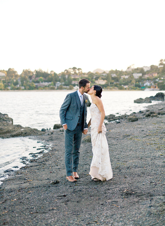 Bride and groom kissing by the ocean