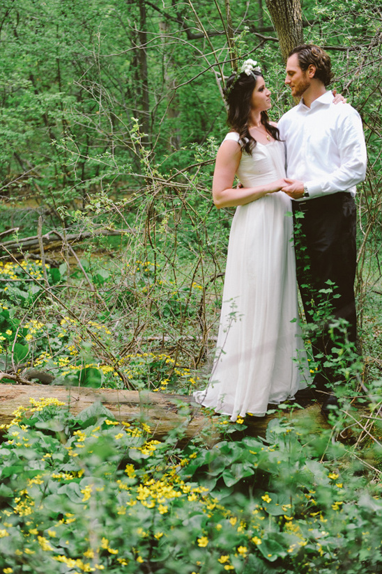 Bride and groom embrace in a blossoming forest scene