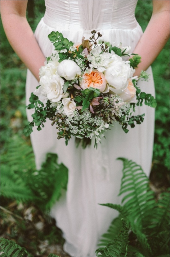 Bride holds a wildflower bouquet in an outdoor wedding