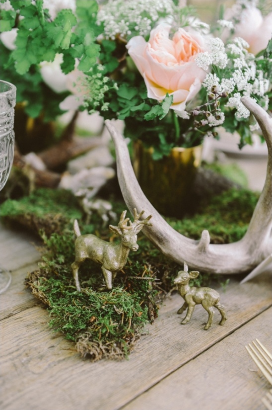 Floral table centerpiece with deer figurines and antlers