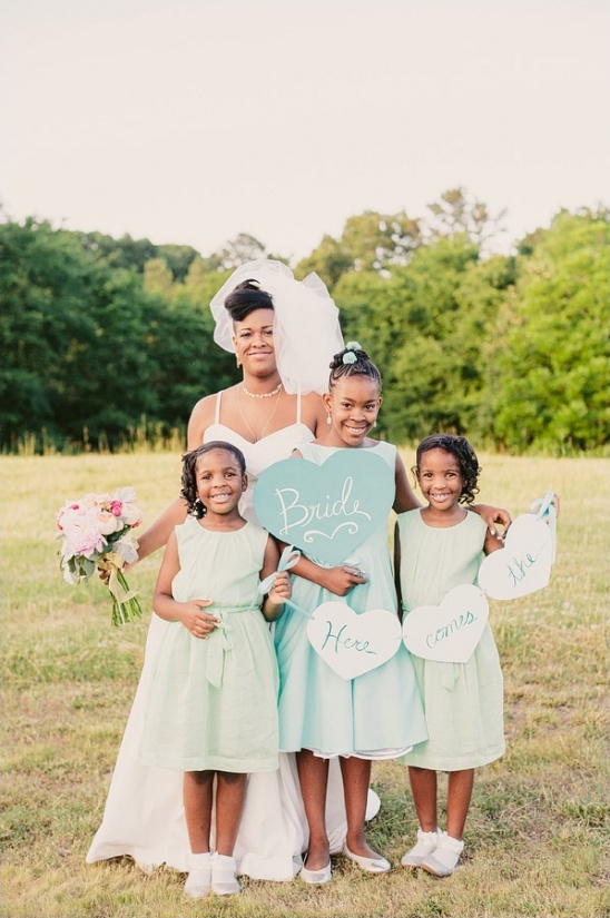Bride with flower girls holding signs