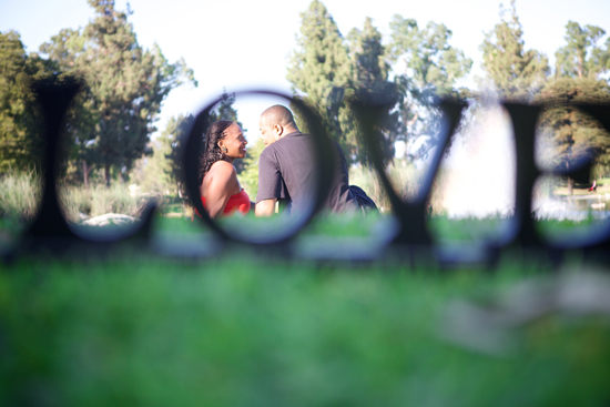 Couple framed by the word love in a park setting