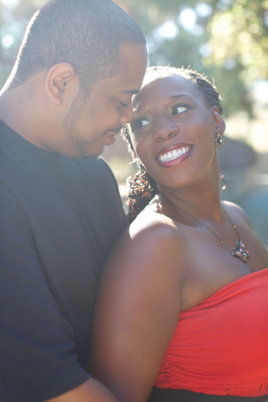 Happy couple smiling at each other outdoors in sunlight