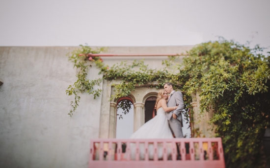 Bride and groom on romantic ivy covered balcony