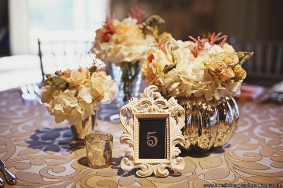 Elegant floral centerpiece with table number five in frame