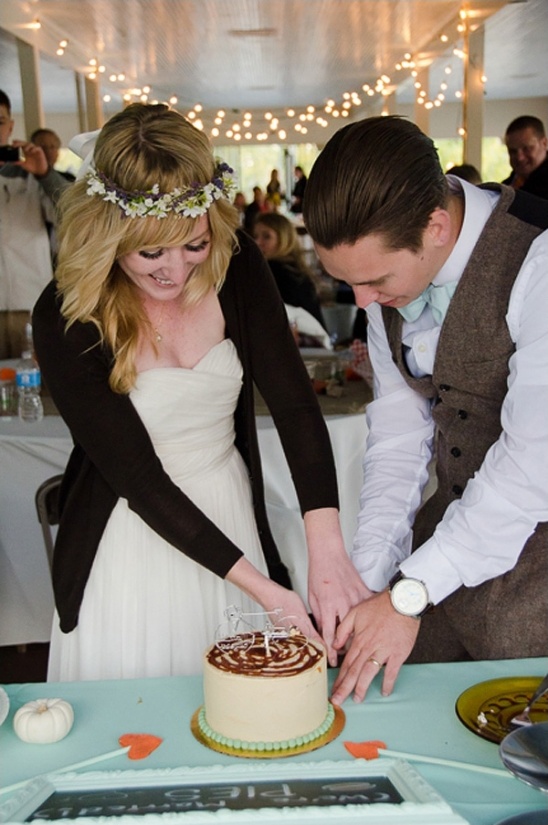 cutting the mini wedding cake from tee & cakes