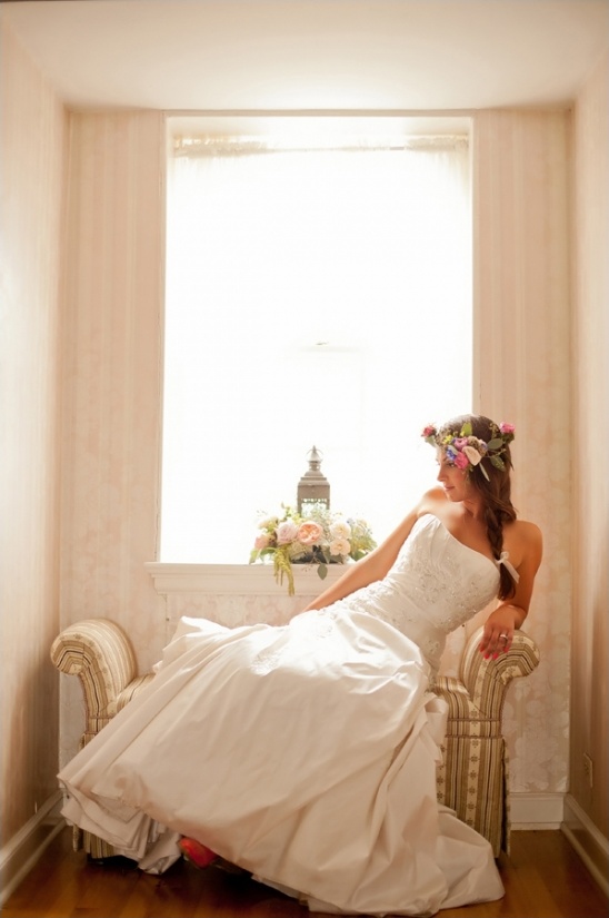 Bride in floral crown and white dress on chair