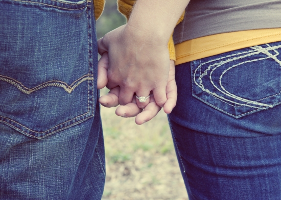 Couple holding hands, ring visible