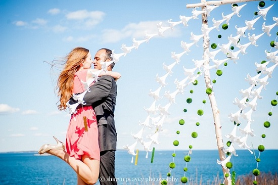 Romantic couple embracing by floral wedding arch
