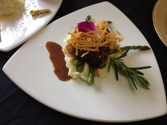 Beef dish with mashed potatoes, asparagus, and garnish