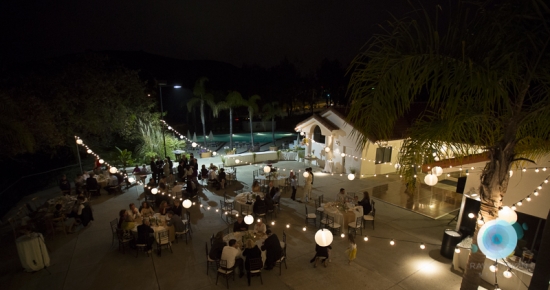 Nighttime wedding reception with string lights and guests