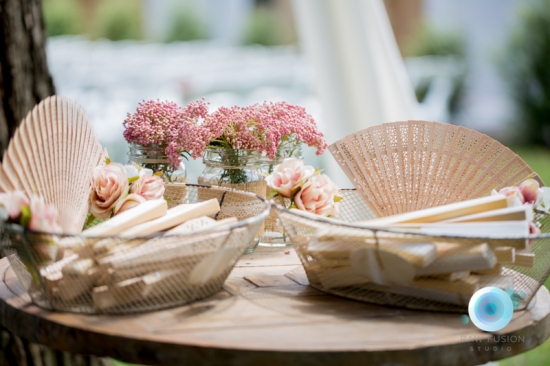 Wedding favors fans and flowers on wooden table