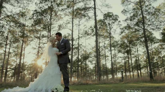 Bride and groom kissing in a forest wedding scene