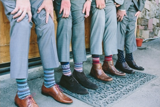 Groomsmen in gray suits show off colorful socks