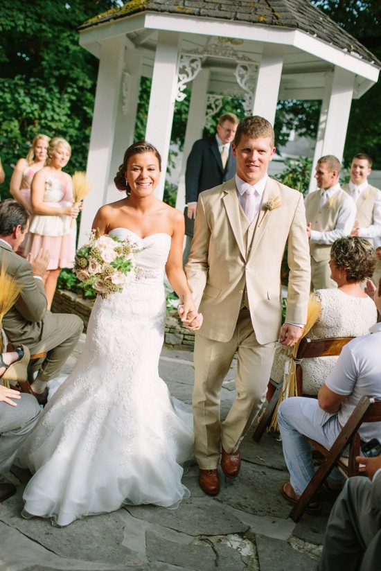 Bride and groom exiting wedding gazebo happily