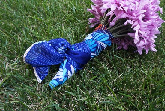 Blue patterned fabric wraps a purple flower bouquet