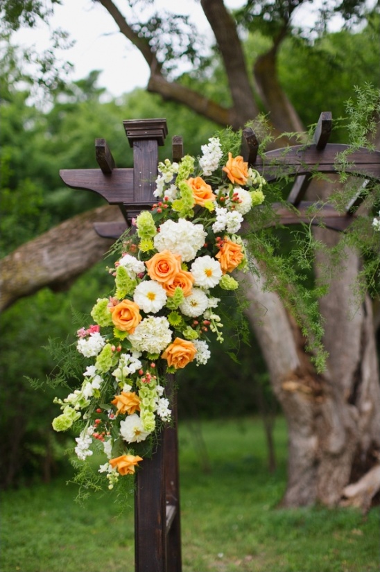 Floral arrangement on a rustic wedding arbor outdoors
