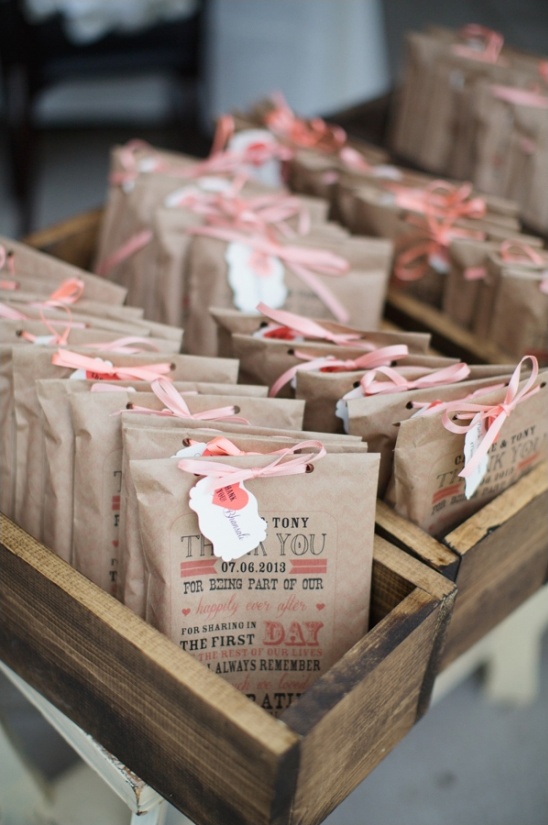 Wedding favor bags with ribbons in rustic wood tray