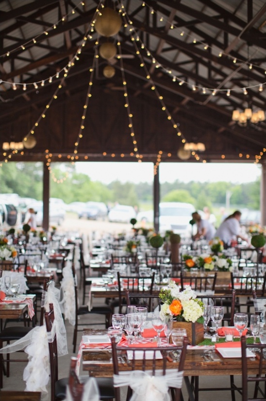 Outdoor wedding reception with lights and floral centerpieces