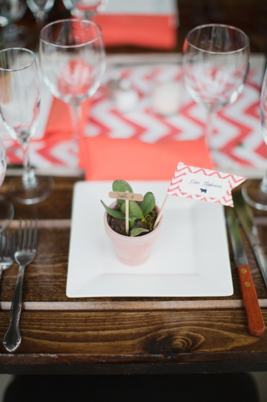 Coral and white wedding table setting with plant favor