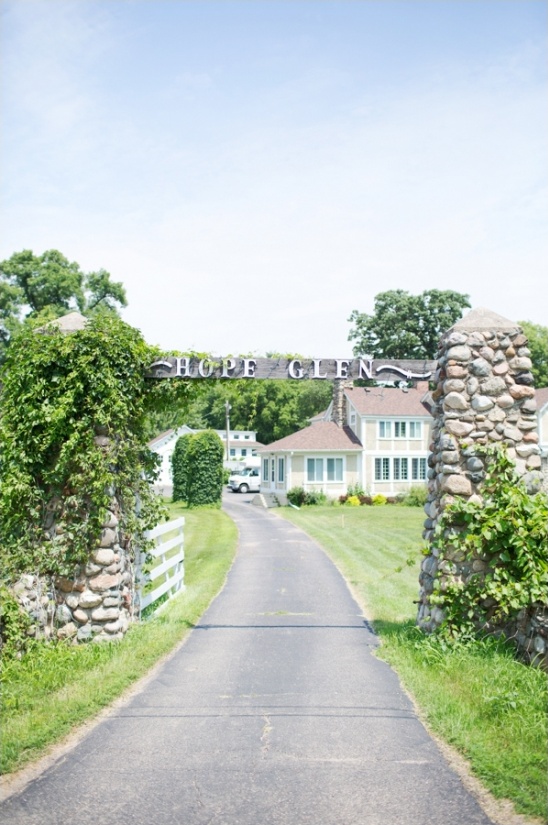 Hope Glen entrance with stone pillars and a charming house