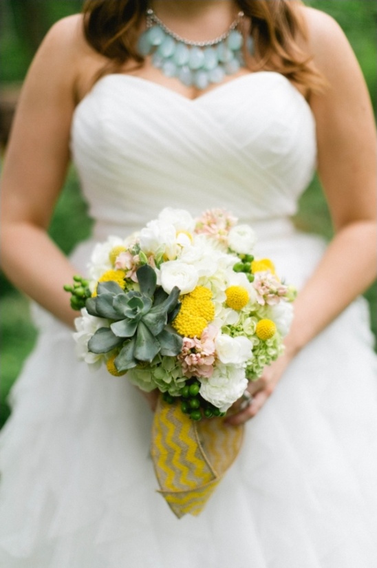 Bride holding yellow and white wedding bouquet