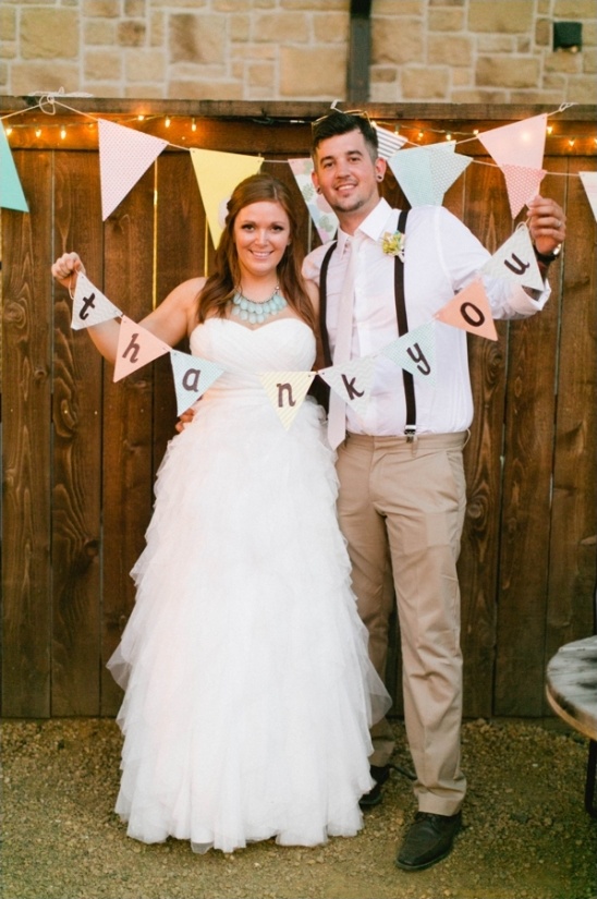 Couple holding thank you banner at wedding