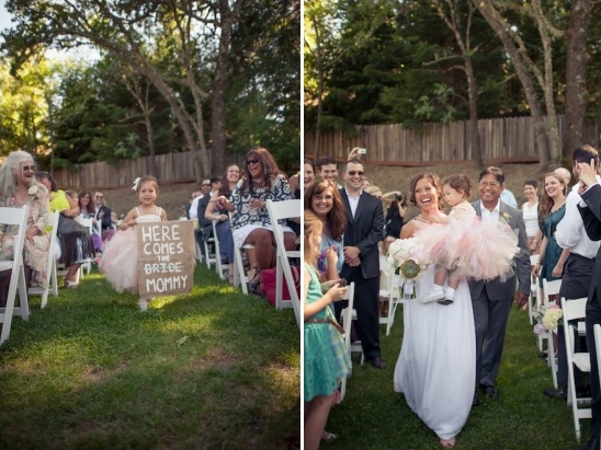 Bride walks down aisle with flower girl holding sign