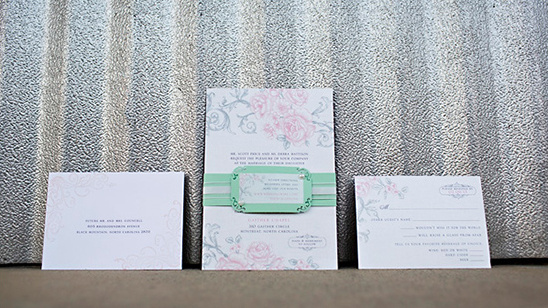 Elegant rose themed wedding invitation suite flat lay