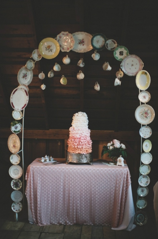 Wedding cake on a table decorated with plates and teacups