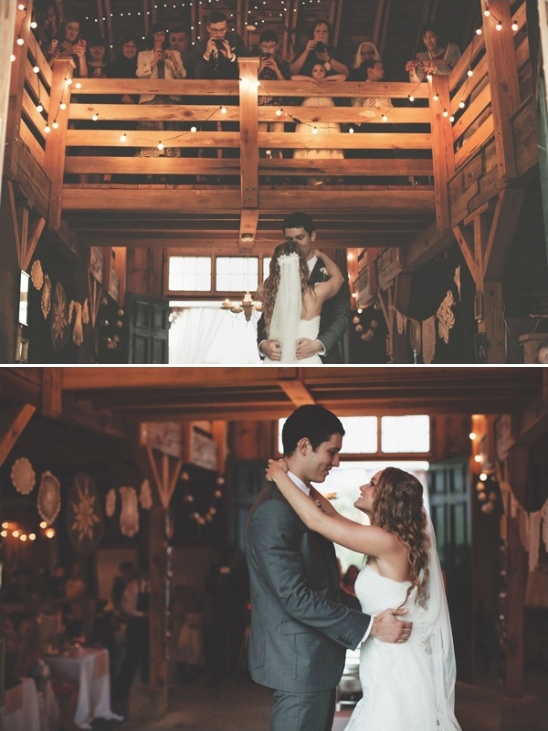 Newlyweds share a first dance in a rustic barn wedding setting