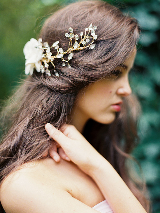 Woman with long brown hair and floral hairpiece