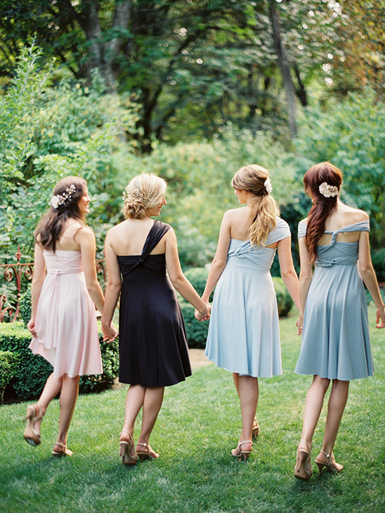 Bridesmaids in pastel dresses walking in garden
