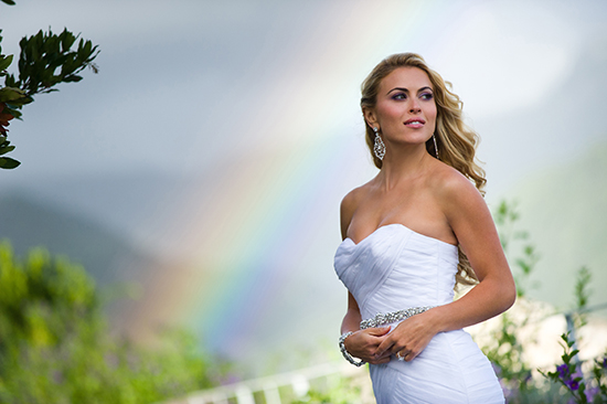 Stunning bride in white wedding gown, rainbow backdrop