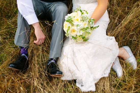 Bride and groom relaxing on a sunny day, bouquet in hands