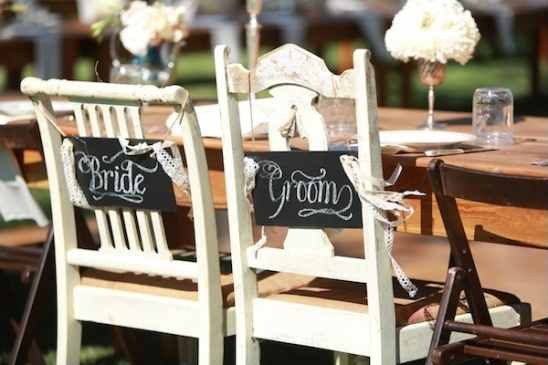 bride and groom signs on chairs