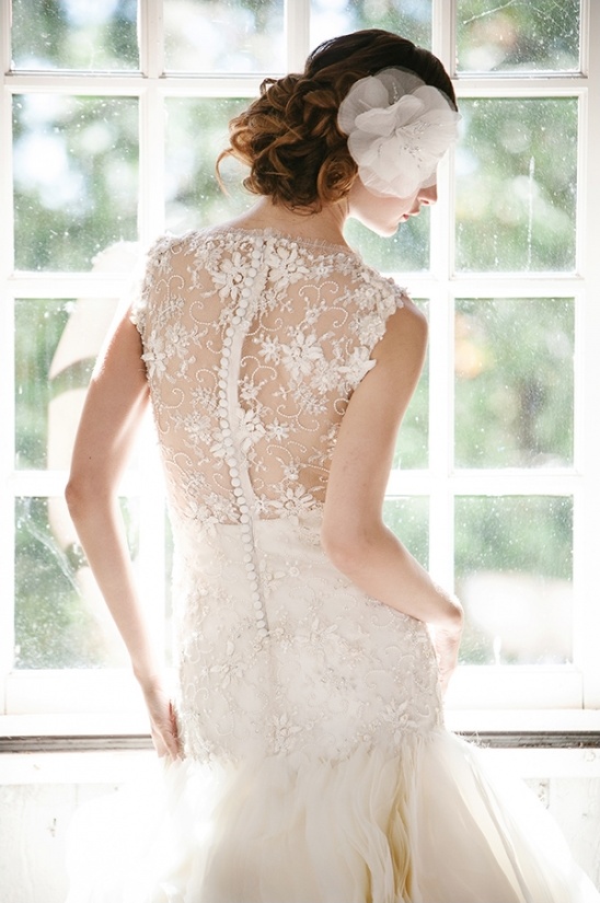 Elegant bride in a beautiful lace wedding dress by the window