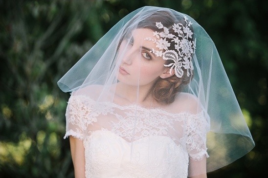 Elegant bride wearing a lace wedding dress and veil outdoors