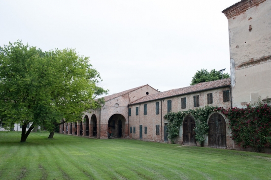 Ancient Italian villa with arched entrance and a vast green lawn