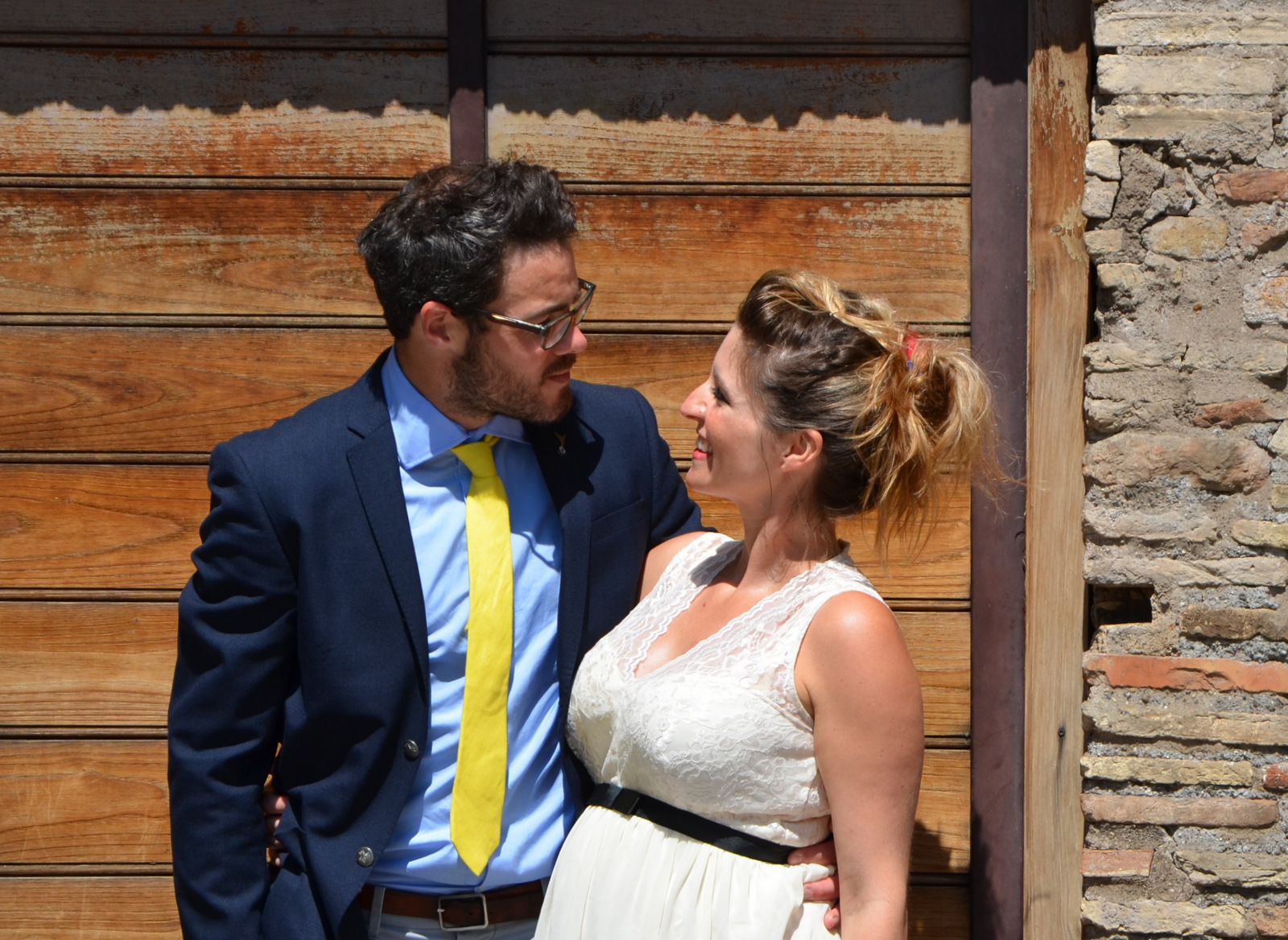 Smiling couple embracing in front of a wooden door, lovely moment