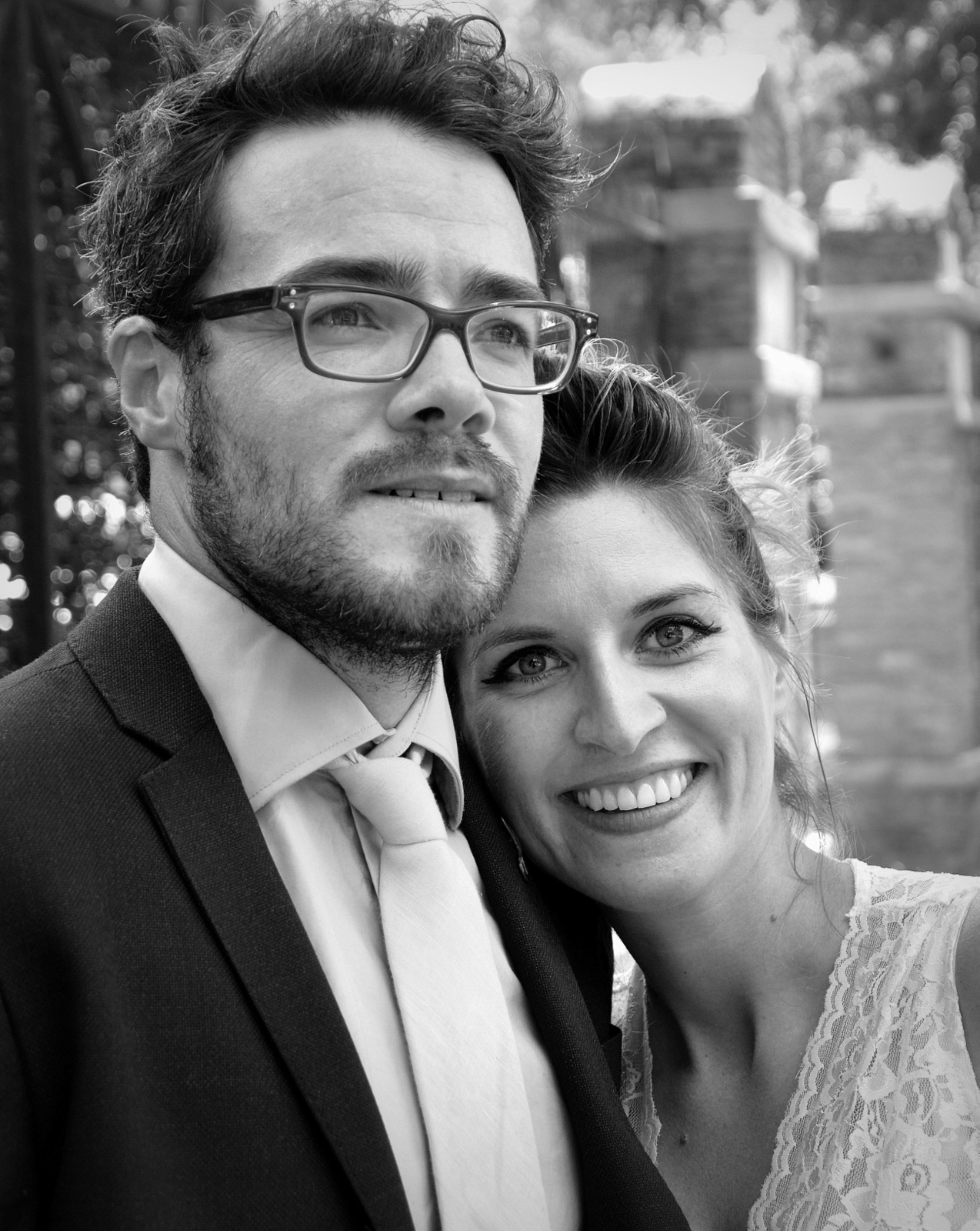 Happy couple smiling at the camera in a black and white portrait