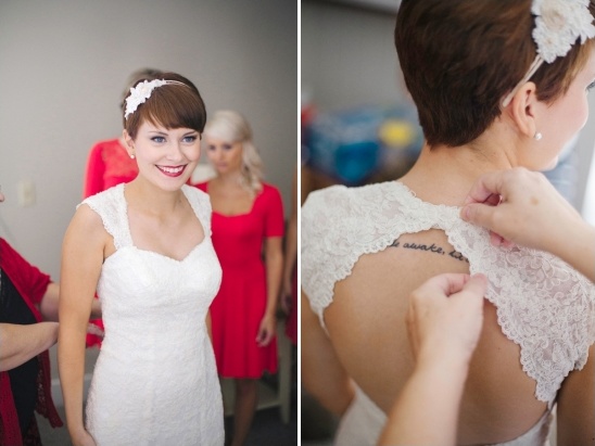 Smiling bride in dress with bridesmaid; tattoo visible on her back
