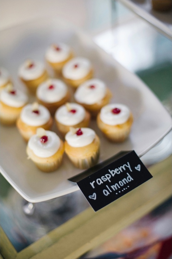 Mini raspberry almond cupcakes on a white platter, delicious treats